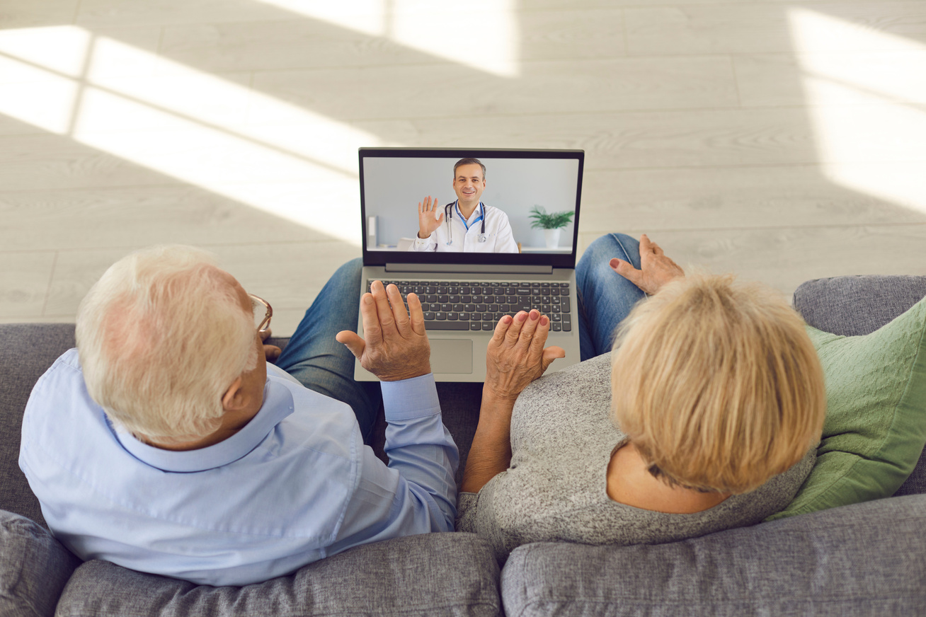 Couple looking at a computer with a doctor on the screen