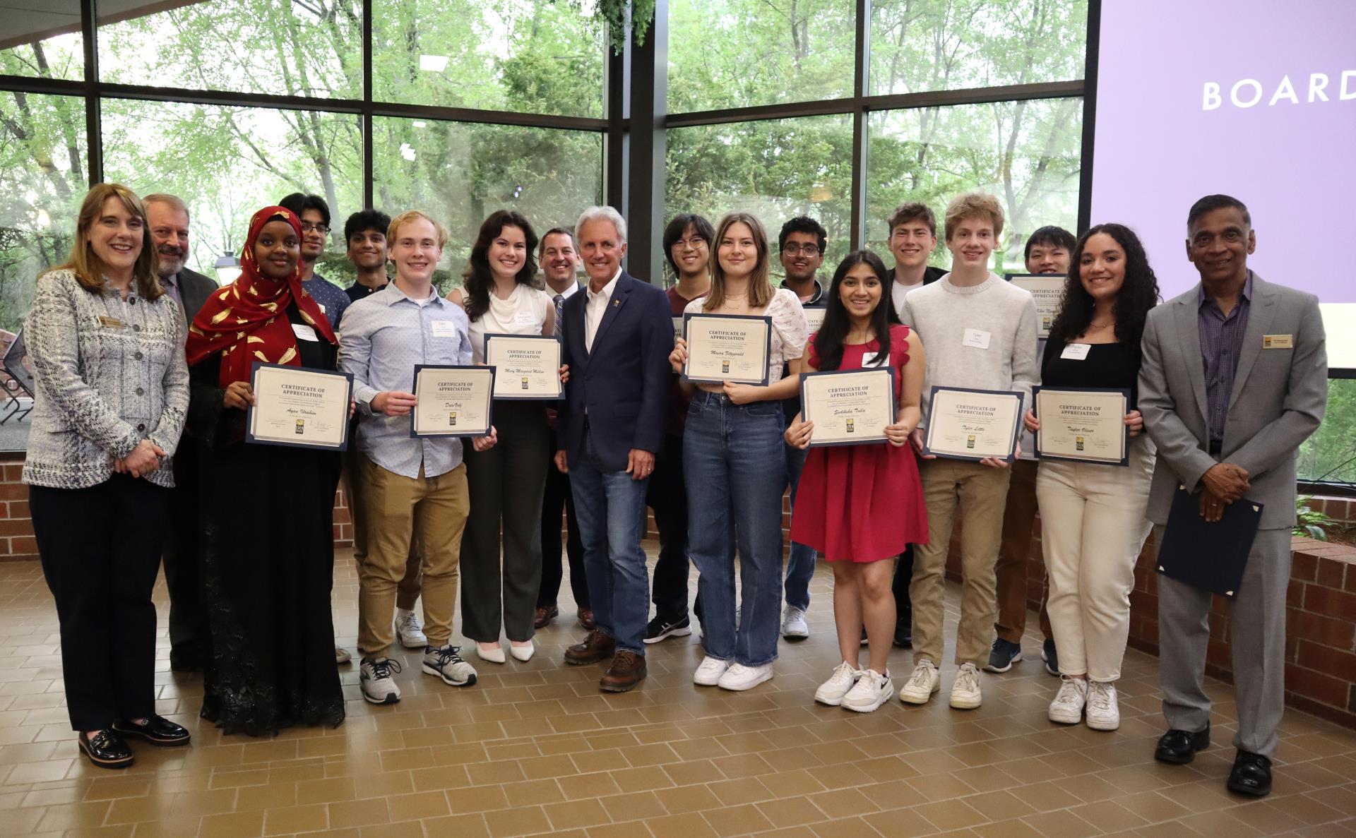 Large group of students posing for a photo with Council Members, Mayor and school district Superintendent