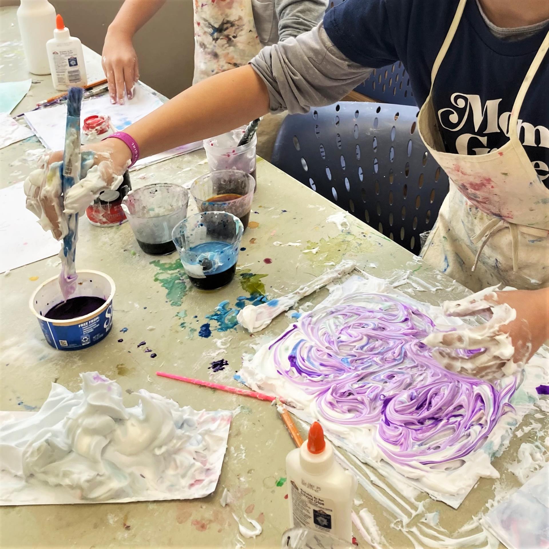 participants paint with shaving cream and colors during Story and Art Time