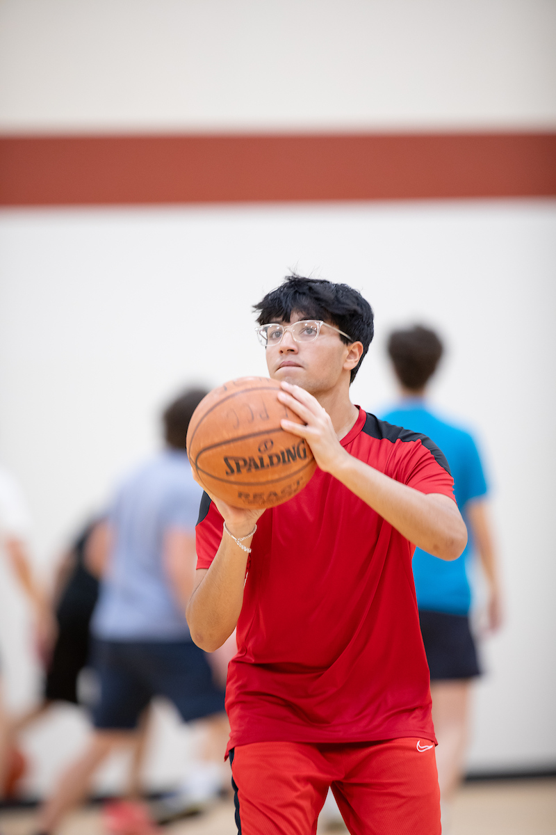 Individual holding a basketball in the Community Center gym