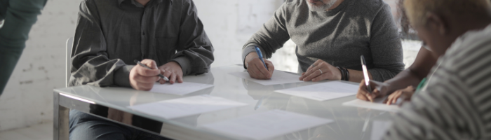 People sitting around table and writing