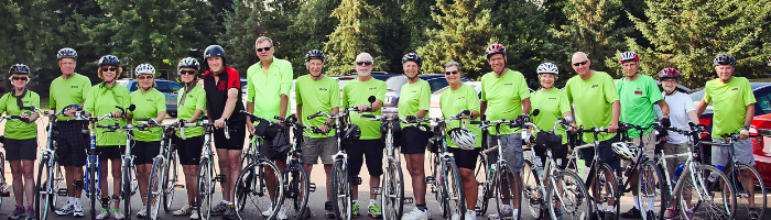 Long row of bicyclists in matching green T-shirts